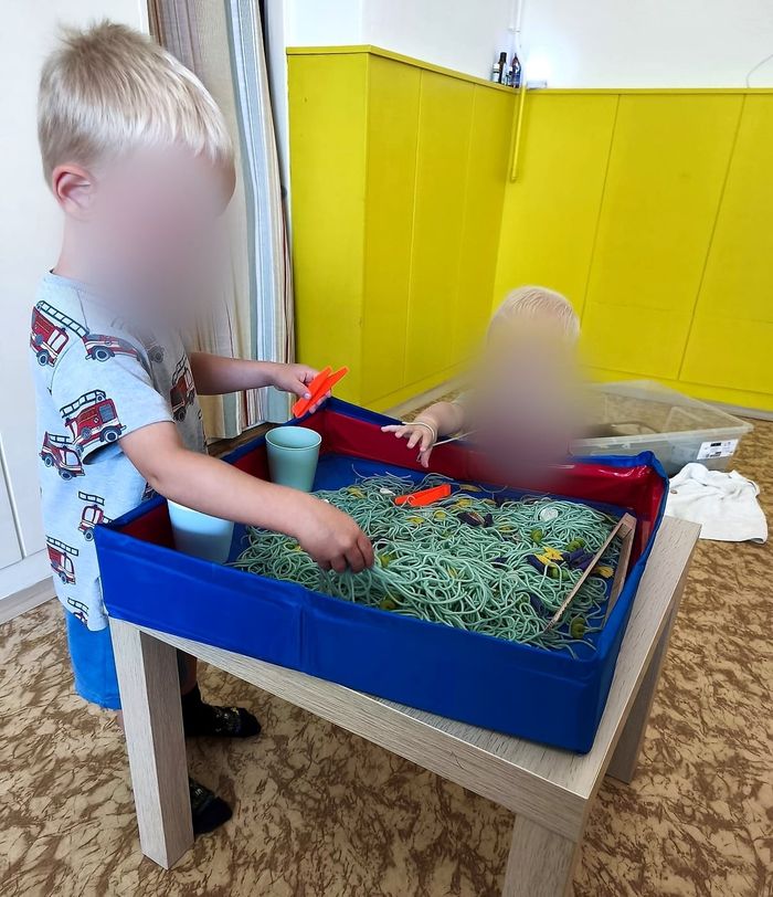 Chlapečci prozkoumávají barevné těstoviny kolíčky